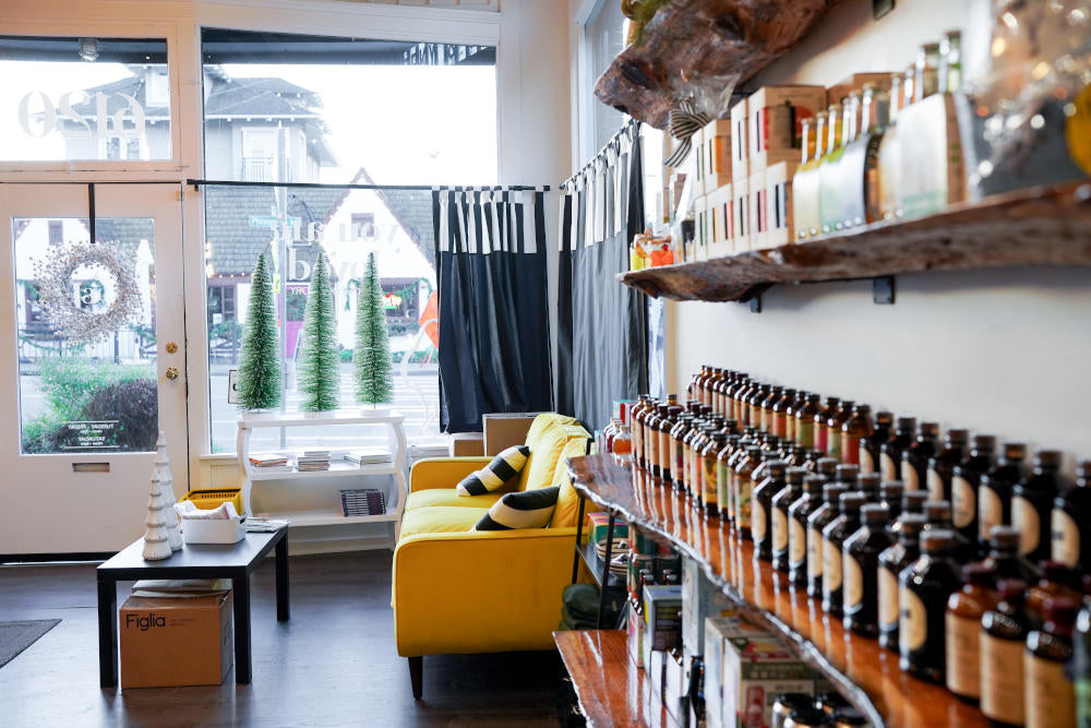 bottle-lined wall next to a comfy yellow couch looking out the front window