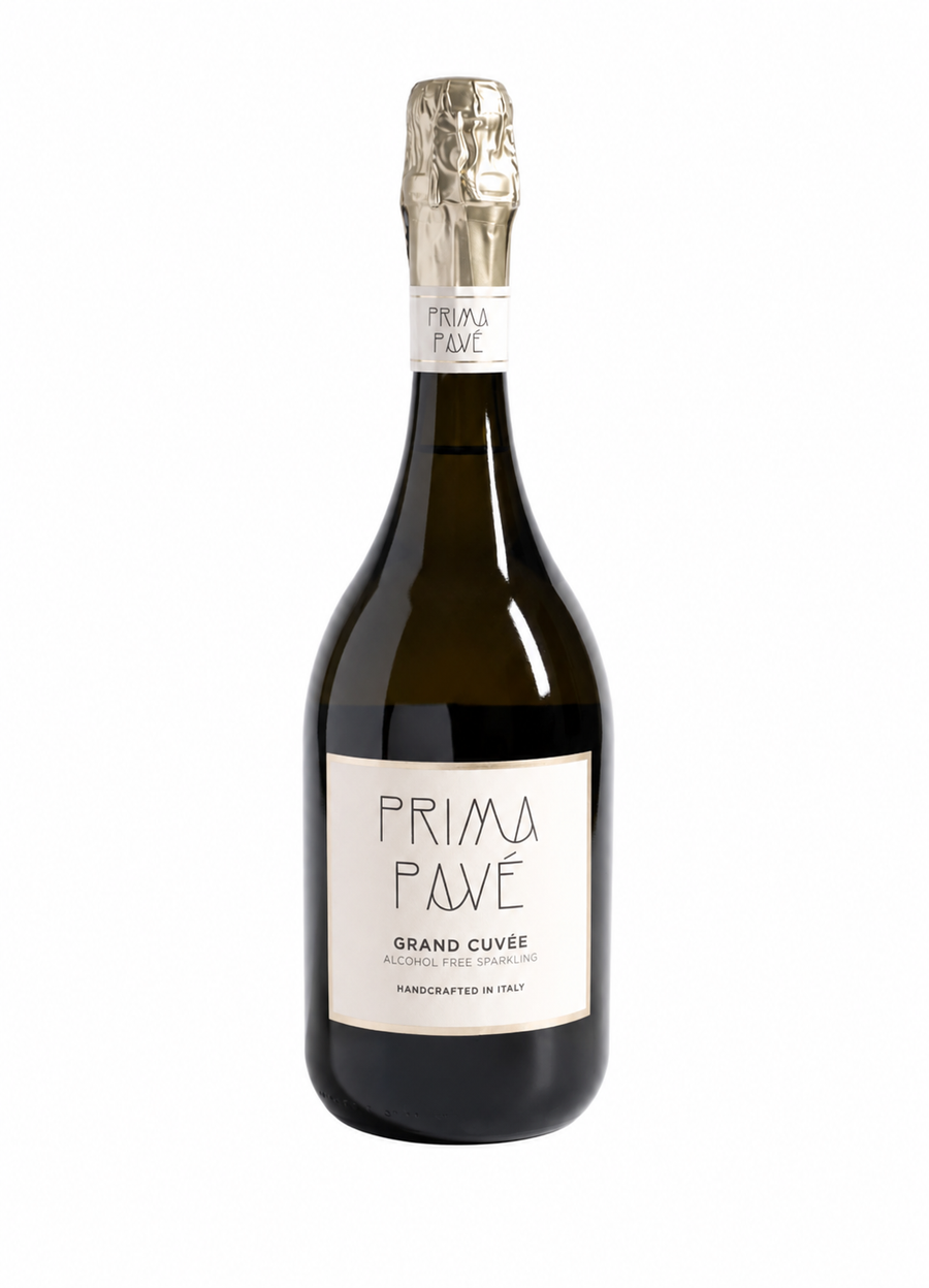 A bottle of Prima Pavé Grand Cuvée sparkling wine, featuring a dark glass bottle with a cream-colored label and a gold foil-wrapped neck, set against a plain white background.